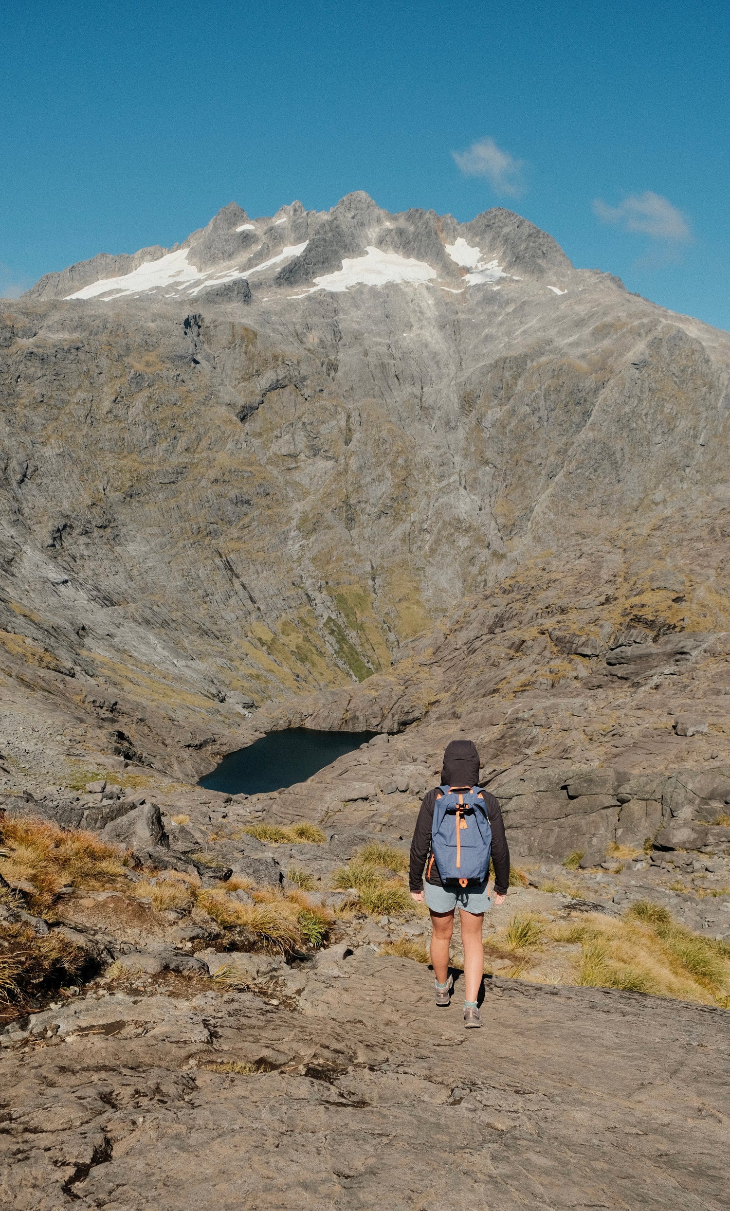 Person on a hike in Milford Sound, New Zealand, wearing a PolyCore backpack coated with our fully recyclable ReCirX²